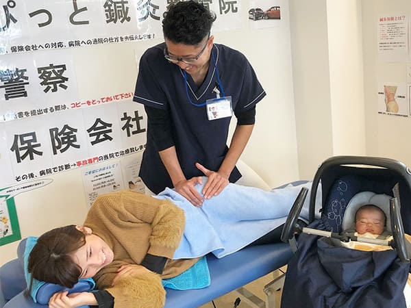 赤ちゃん連れで施術を受けている女性